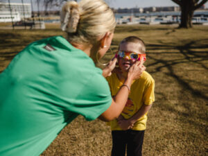 A woman places eclipse glasses on her son's face